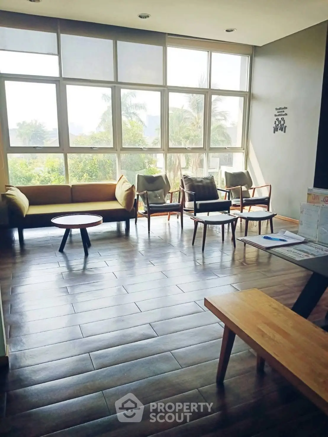 Spacious living room with large windows and modern furniture, offering a bright and inviting atmosphere.