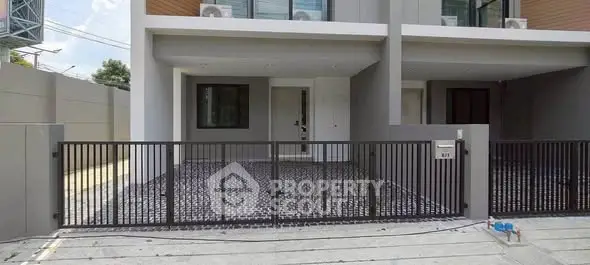 Modern townhouse exterior with gated entrance and sleek design