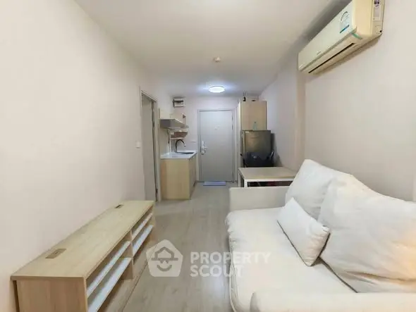 Cozy living room with modern furnishings and air conditioning in a compact apartment.