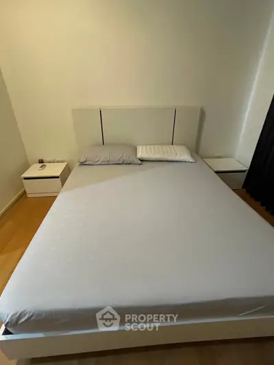 Modern bedroom with minimalist design featuring a sleek bed and side tables, perfect for urban living.
