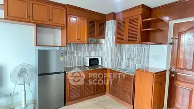 Charming kitchen with wooden cabinets and modern appliances in cozy apartment.