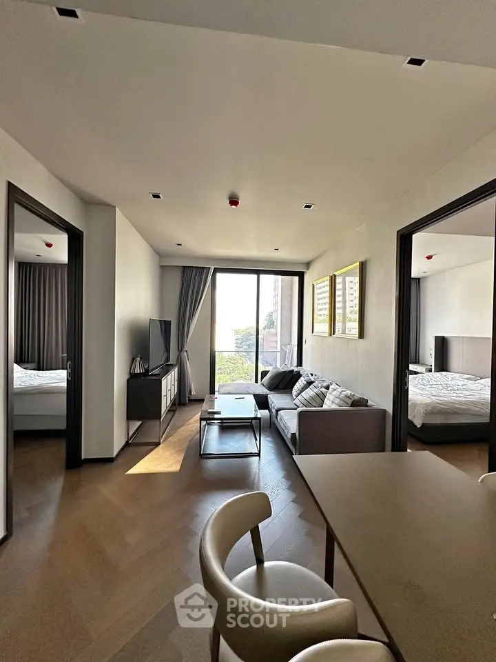 Modern living room with elegant decor and natural light, featuring a cozy seating area and stylish furniture.