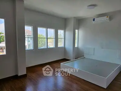 Spacious bedroom with large windows and modern air conditioning unit