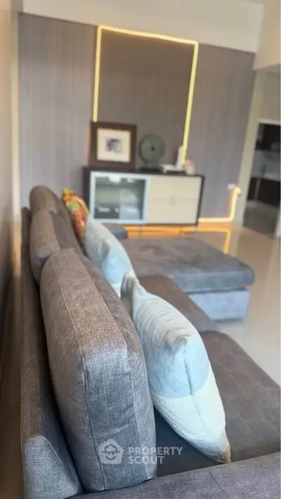 Modern living room with stylish gray sofa and elegant decor, perfect for relaxation and entertainment.