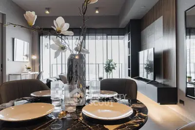 Elegant dining area seamlessly connects to a modern living space with stylish decor and abundant natural light, perfect for urban living.