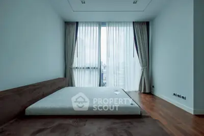 Spacious minimalist bedroom with large windows and elegant curtains