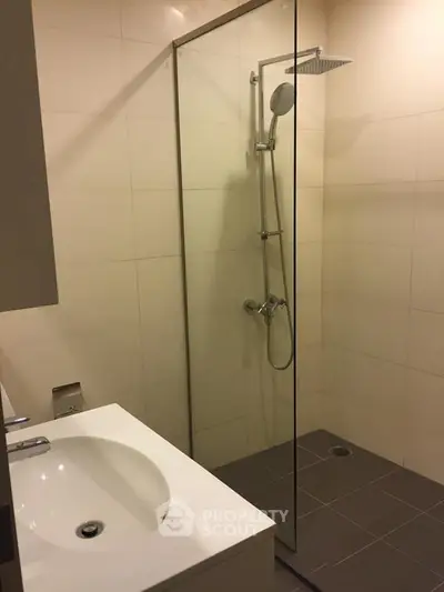 Modern bathroom with sleek shower and elegant sink in a contemporary apartment.