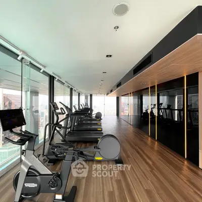 Modern gym with city view featuring state-of-the-art exercise equipment and sleek design.