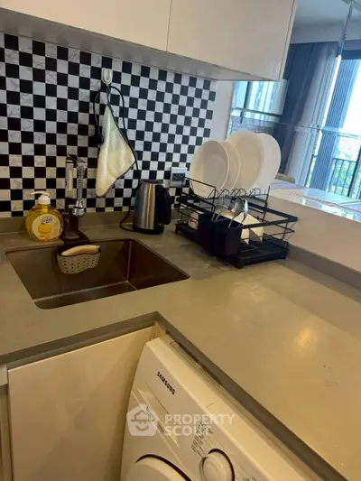 Modern kitchen with sleek countertop and built-in washing machine