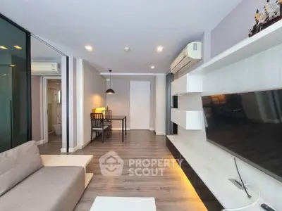 Modern living room with sleek design, featuring a wall-mounted TV and stylish furniture.