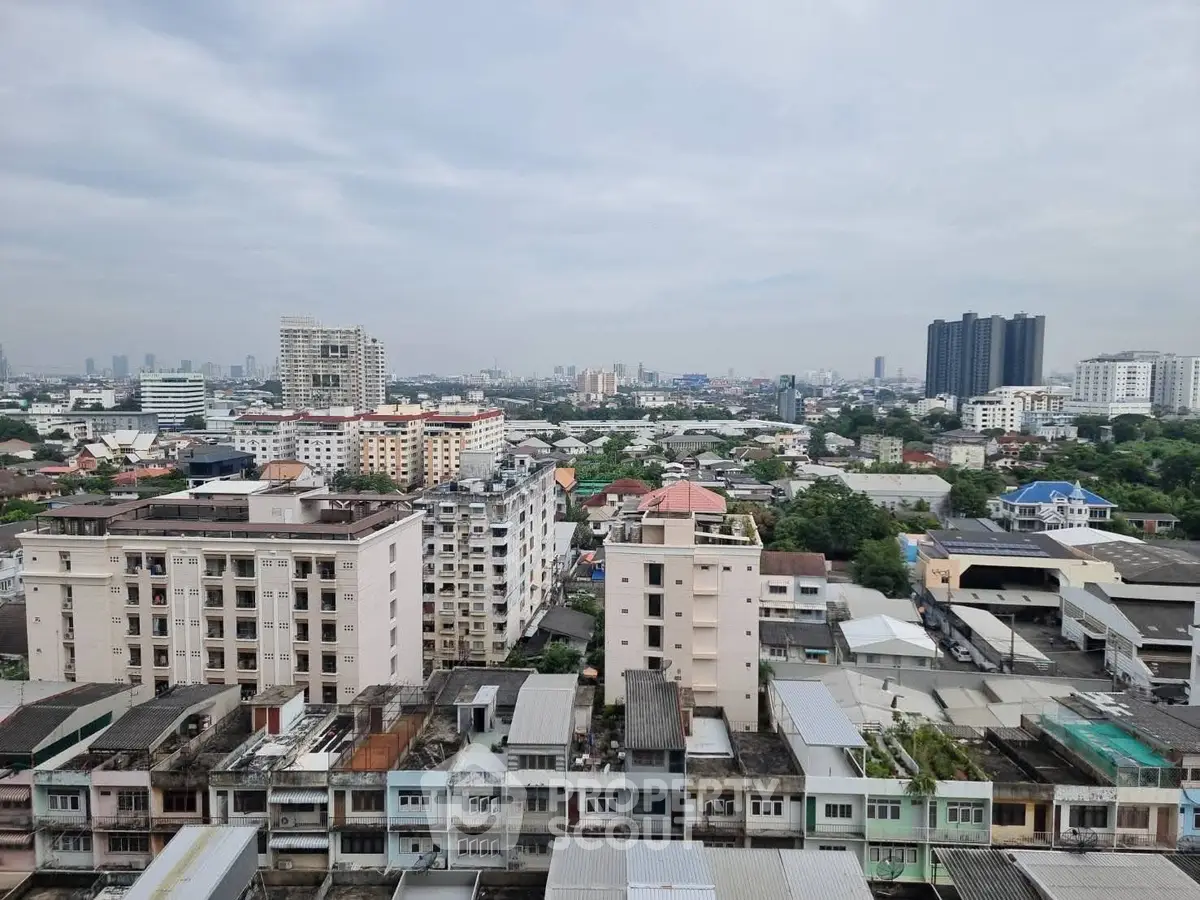 Panoramic cityscape view from high-rise building showcasing urban skyline and residential areas.