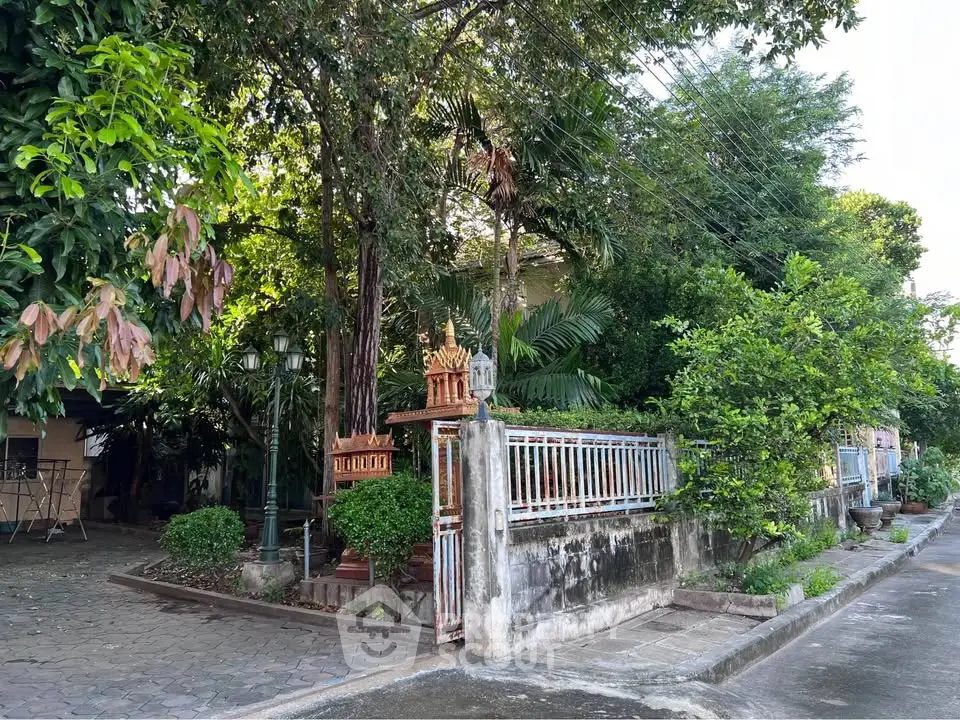 Charming residential property with lush greenery and gated entrance