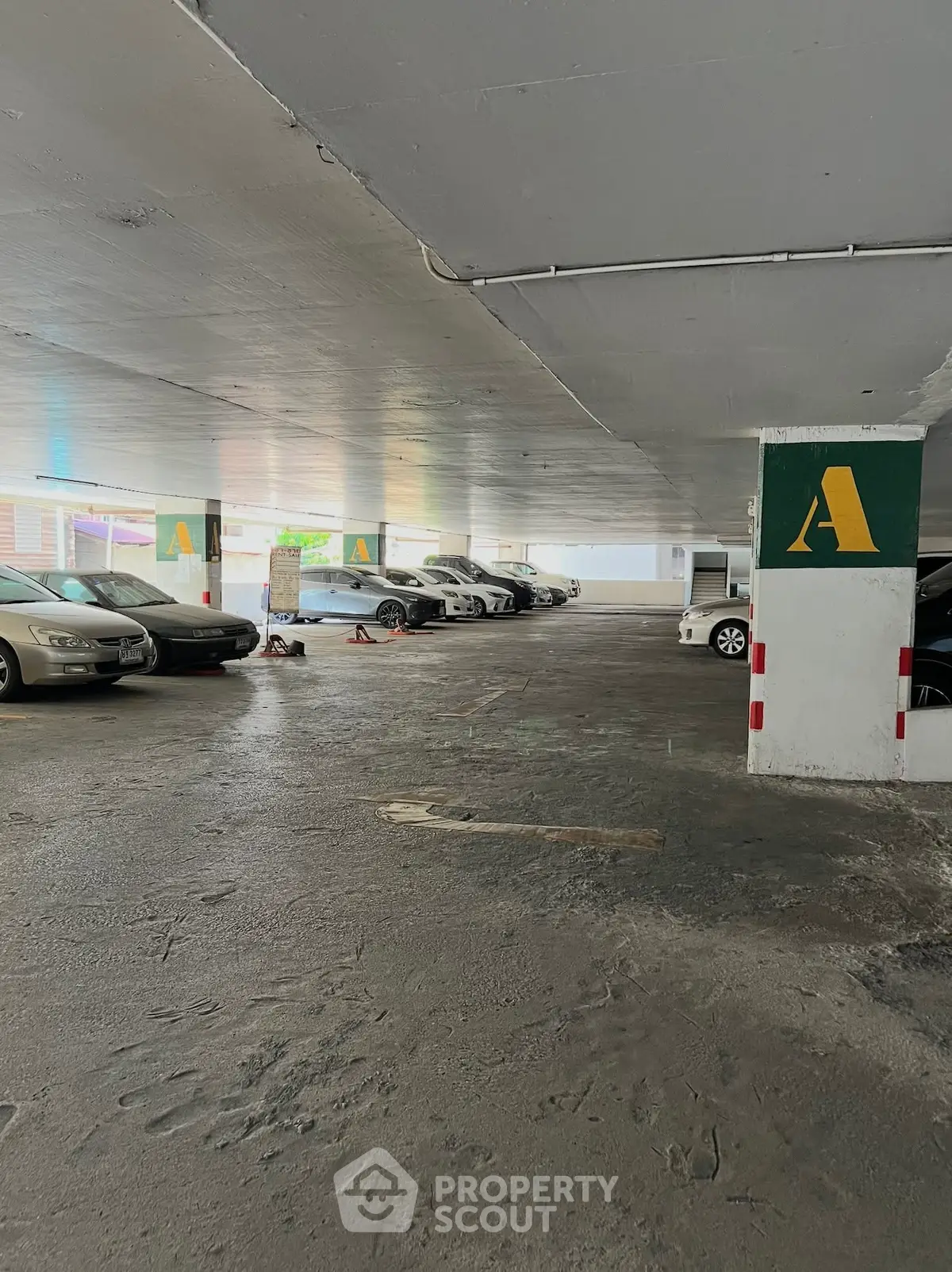 Spacious underground parking area with multiple cars and clear signage for easy navigation.