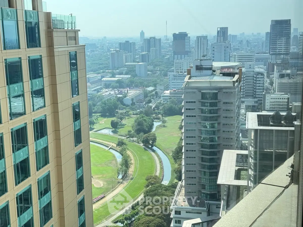 Stunning cityscape view from high-rise building with lush green park below, perfect for urban living enthusiasts.