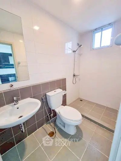 Modern bathroom with sleek fixtures and walk-in shower in a bright, tiled space.