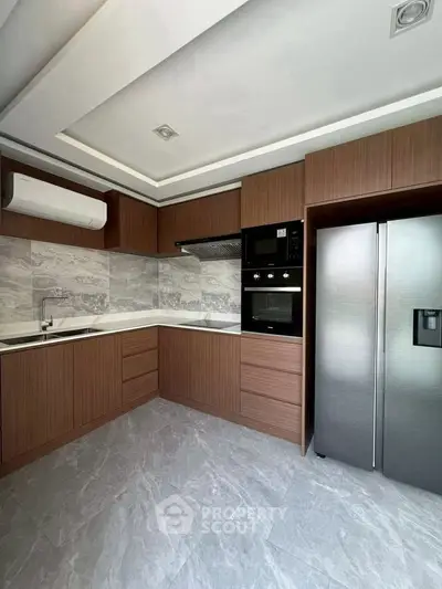 Modern kitchen with sleek cabinetry and stainless steel appliances in a contemporary home.