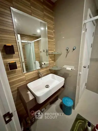 Modern bathroom with stylish sink and wooden accent wall