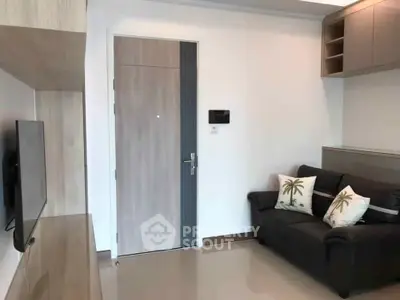 Modern living room with sleek design and cozy sofa, featuring a wall-mounted TV and stylish decor.