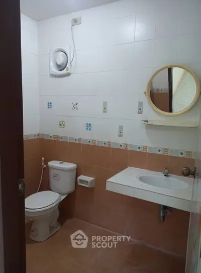 Cozy bathroom with tiled walls and modern fixtures, perfect for a comfortable living space.