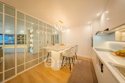 Modern kitchen with sleek design and open layout, featuring elegant lighting and stylish bar seating.