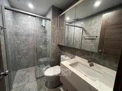 Modern bathroom with sleek marble tiles and glass shower enclosure