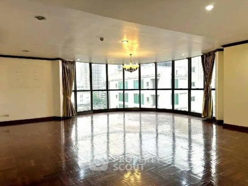 Spacious corner unit with large windows offering city views and elegant hardwood flooring.