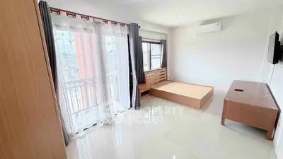 Bright bedroom with large windows and modern furnishings in a stylish apartment.