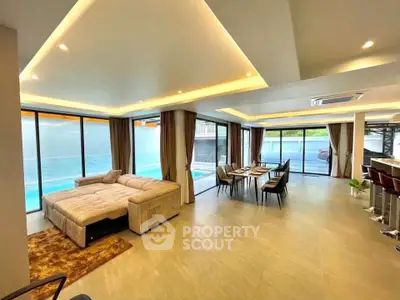 Luxurious open-plan living room with pool view and modern furnishings