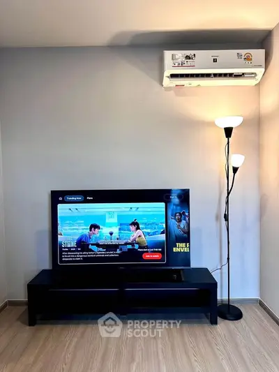 Modern living room with sleek TV setup and air conditioning, perfect for cozy entertainment.