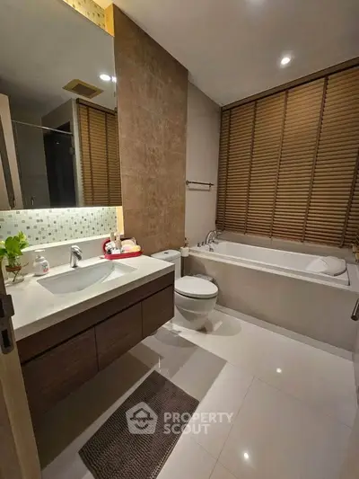 Modern bathroom with bathtub, sleek vanity, and stylish blinds in a contemporary home.