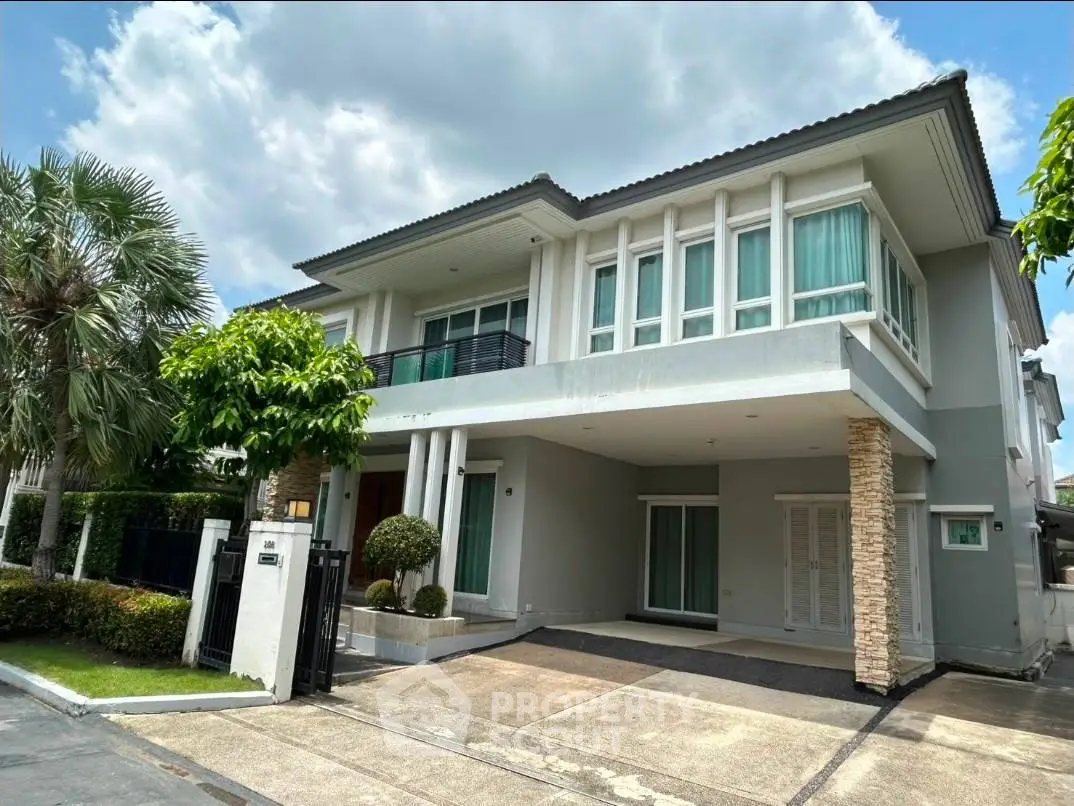 Modern two-story house with spacious driveway and lush greenery, perfect for family living.