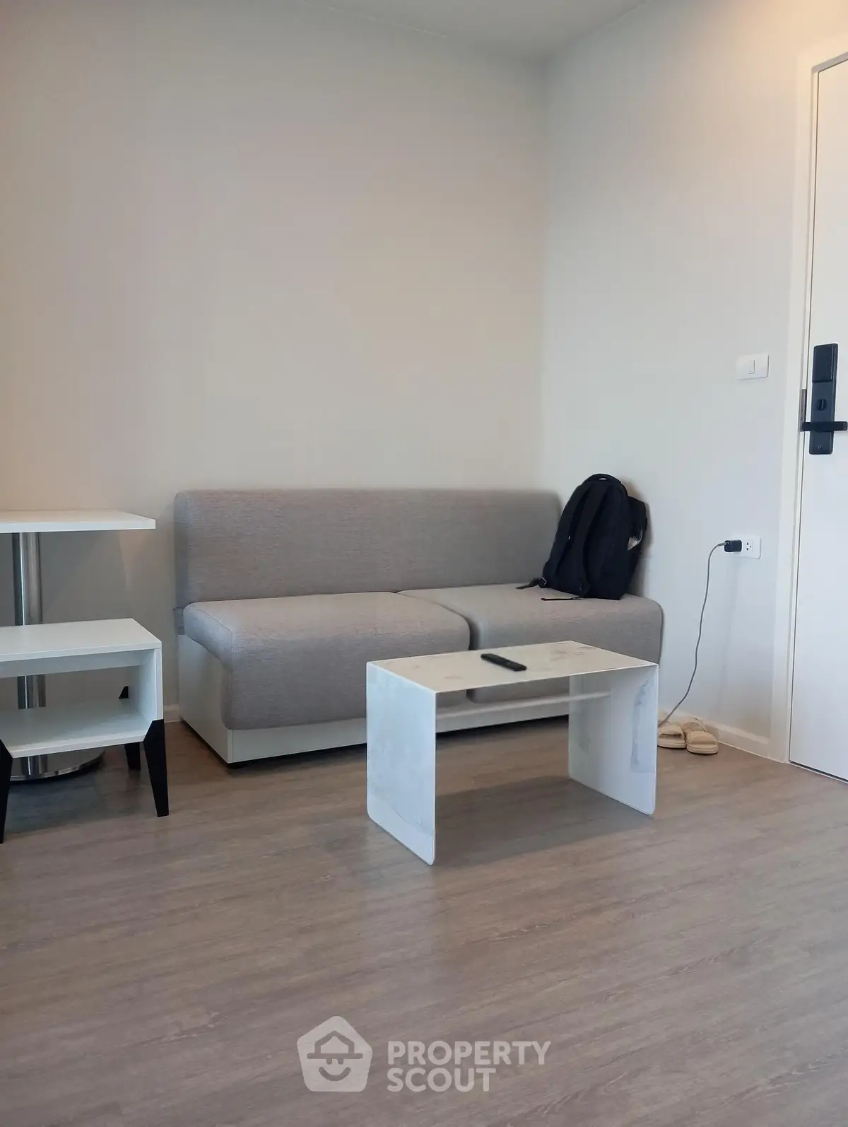 Modern living room with sleek gray sofa and minimalist coffee table in a stylish apartment.