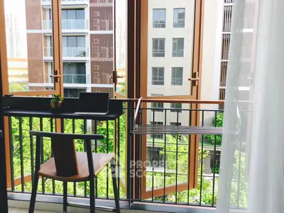 Chic balcony with modern furniture and lush green view in urban setting.