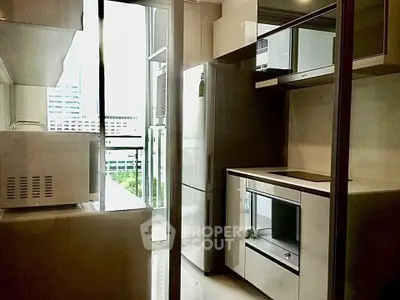 Modern kitchen with sleek appliances and balcony view in urban apartment