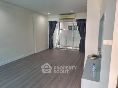 Spacious unfurnished living room with large windows and modern flooring.
