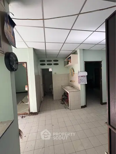 Spacious interior with tiled flooring and open layout, ideal for renovation.