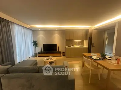 Modern living room with open kitchen, cozy seating, and stylish decor in a contemporary apartment.