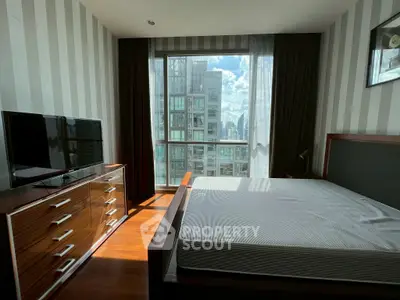Modern bedroom with large window offering city view, featuring sleek furniture and ample natural light.