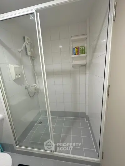 Modern bathroom with glass shower enclosure and tiled walls, perfect for a sleek and clean look.