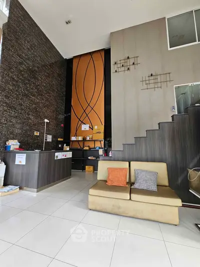 Modern lobby with stylish decor and seating area, featuring high ceilings and elegant design.