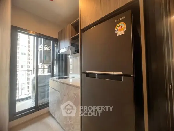 Modern kitchen with sleek fridge and balcony view
