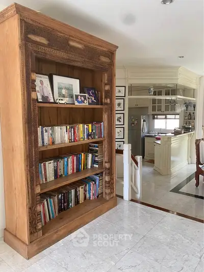 Elegant living space with wooden bookshelf and cozy kitchen area