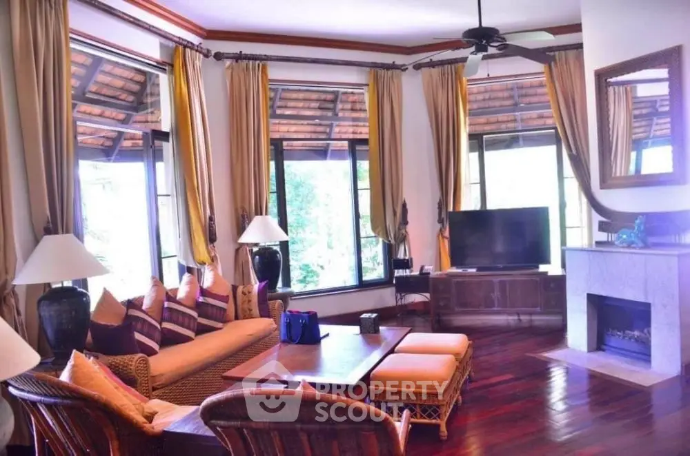 Luxurious living room with elegant decor, large windows, and cozy fireplace in a serene setting.