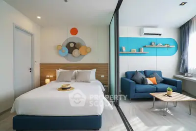 Modern bedroom with stylish decor and cozy seating area, featuring bright accents and natural light.