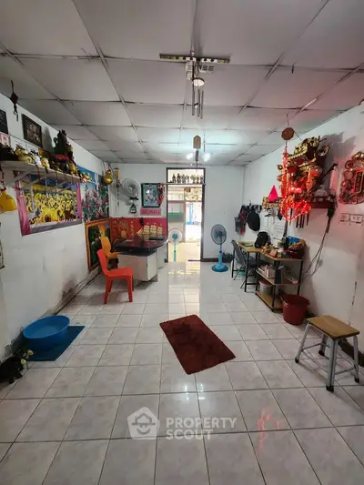 Cozy living room with tiled floor, eclectic decor, and ample natural light.