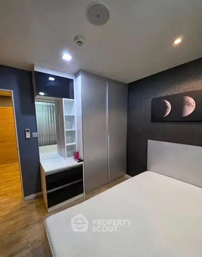 Modern bedroom with sleek wardrobe and moon-themed artwork, perfect for urban living.