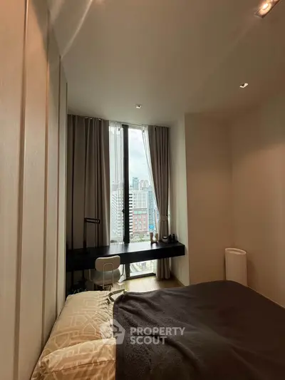 Cozy bedroom with city view, featuring a modern desk and large window for natural light.