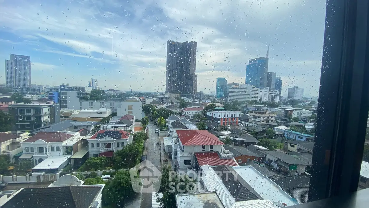 Stunning cityscape view from a high-rise building window on a rainy day.