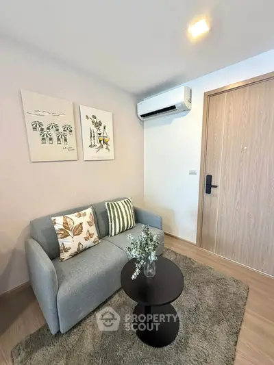 Cozy living room with modern decor and air conditioning, perfect for relaxation.