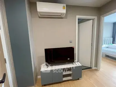 Modern living room with air conditioning and sleek TV setup in stylish apartment.
